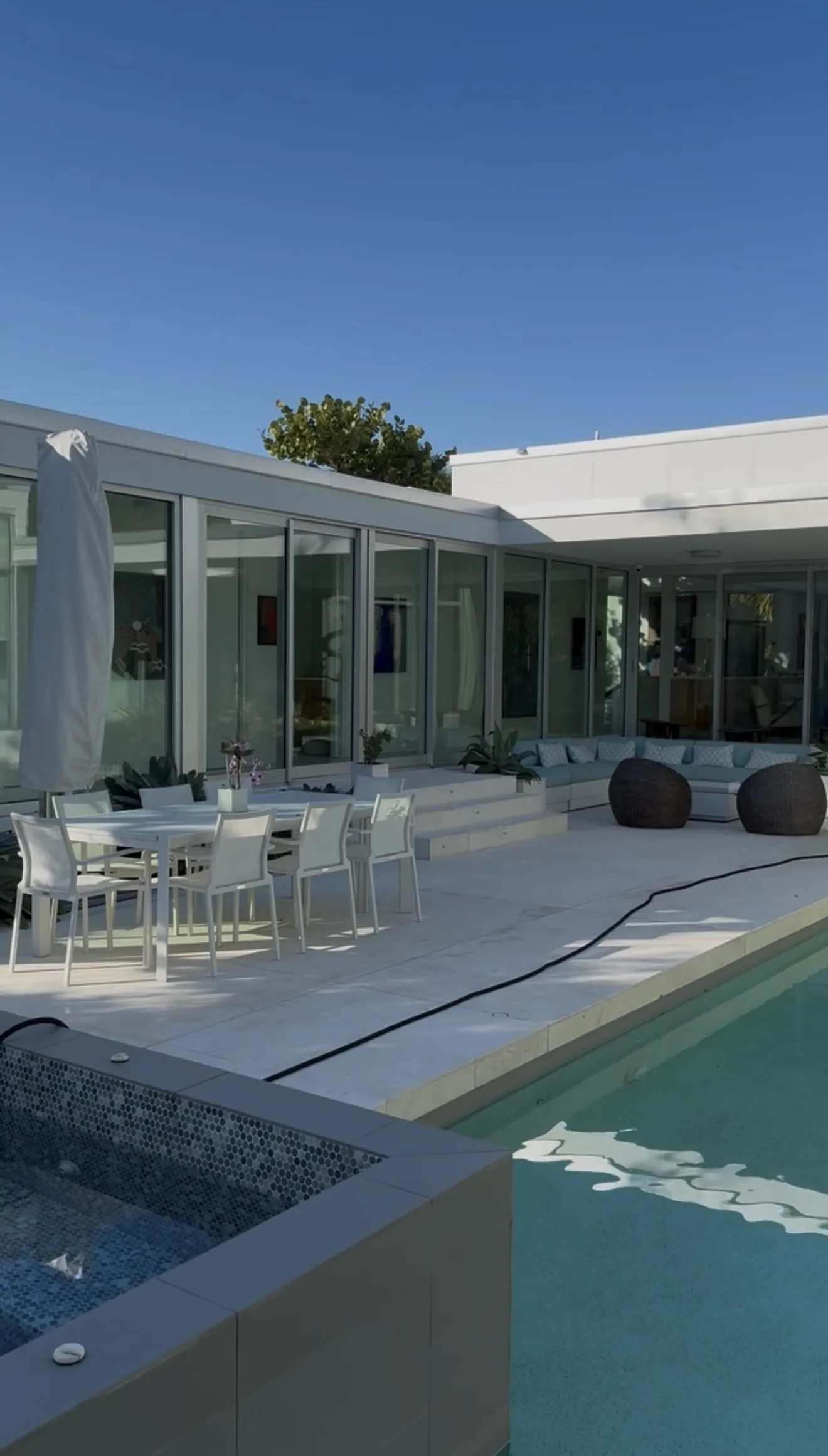 Modern glass home with clean windows and pool deck