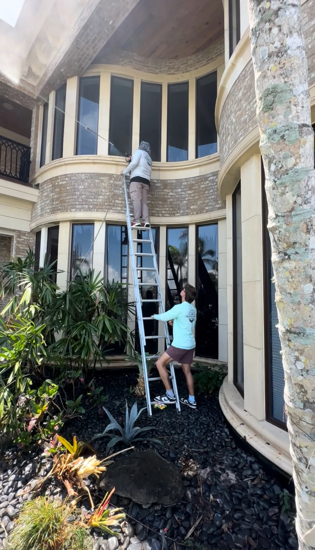 The Sunday Cleaning Co. team cleaning windows on a Sarasota mansion